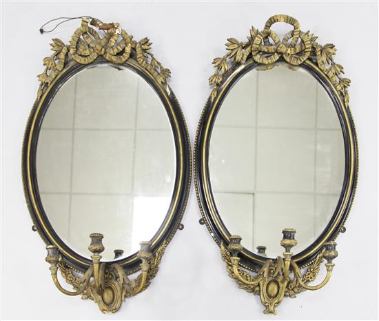 A pair of Victorian oval parcel gilt girandole wall mirrors, H.2ft 11in.